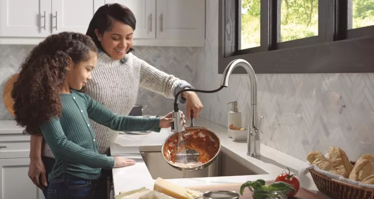 mother and daughter washing a dish