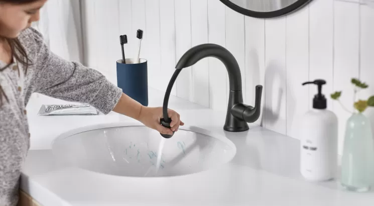 Young person using faucet