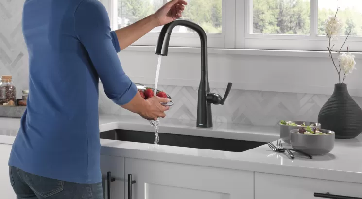 Woman using a touch-activated faucet